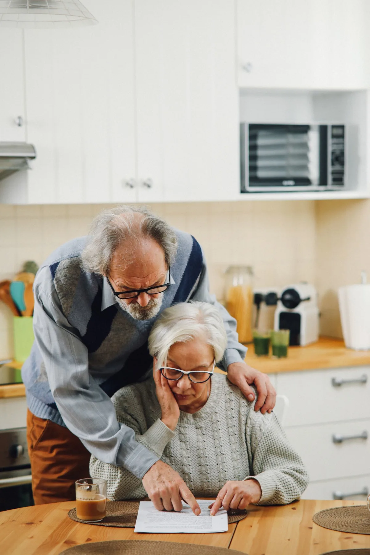 A senior couple reviewing retirement and pension documents together at a kitchen table