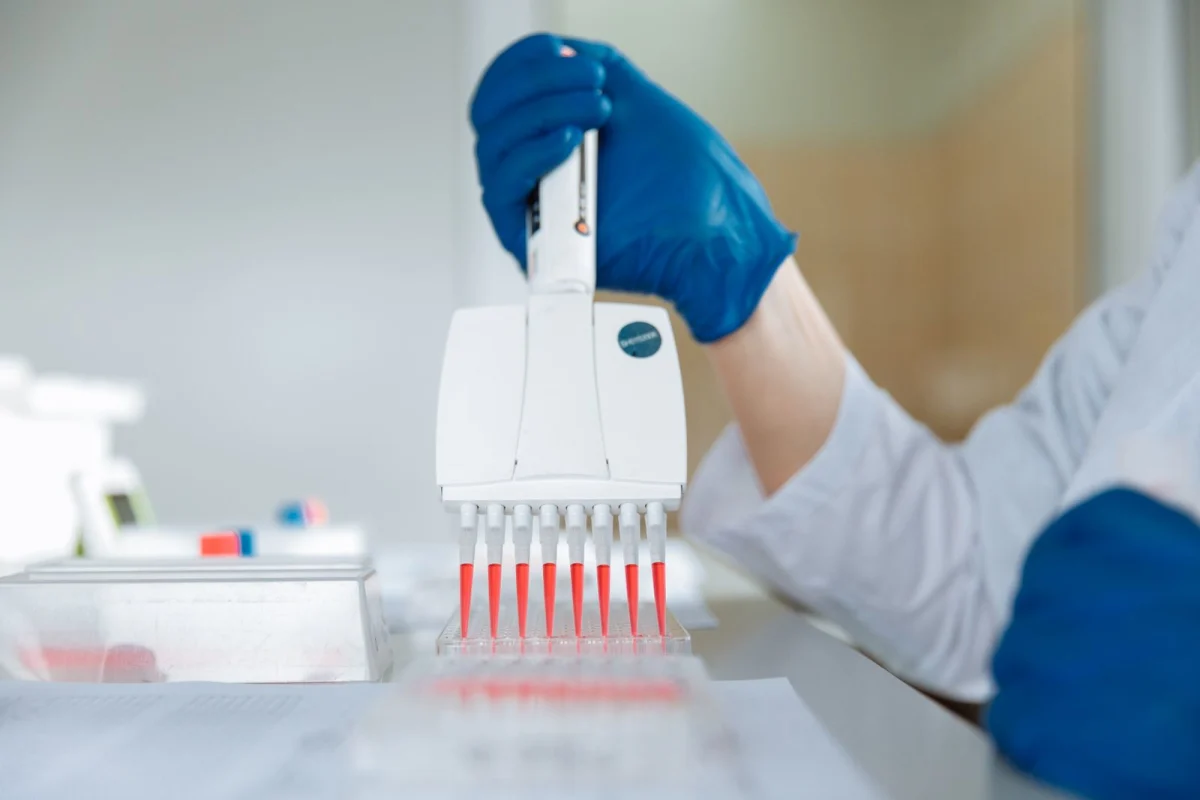 A laboratory worker distributing medication into capsules, representing next-generation weight-loss drug research