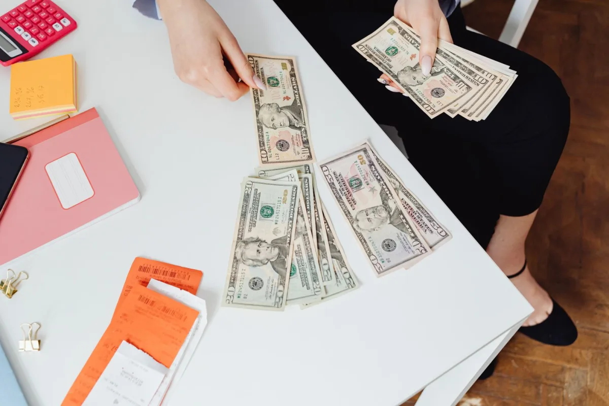 Paper bills beside a calculator on a table, representing a subscription cost audit