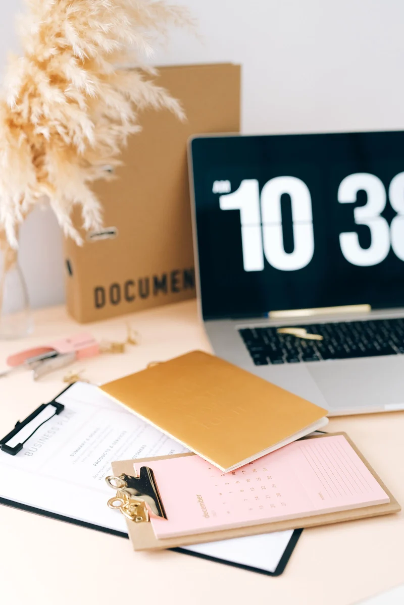 A December desk calendar and a laptop showing a personal finance page in a warmly lit Canadian living room