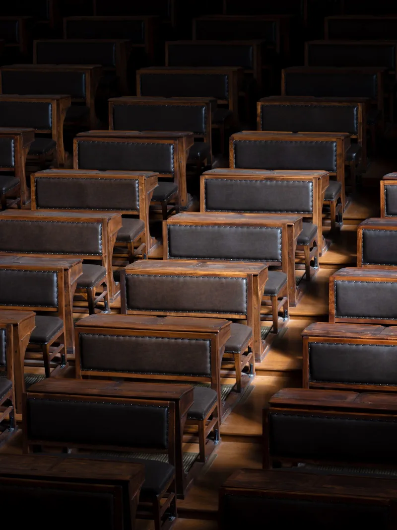 Nearly empty university lecture hall with autumn light through windows