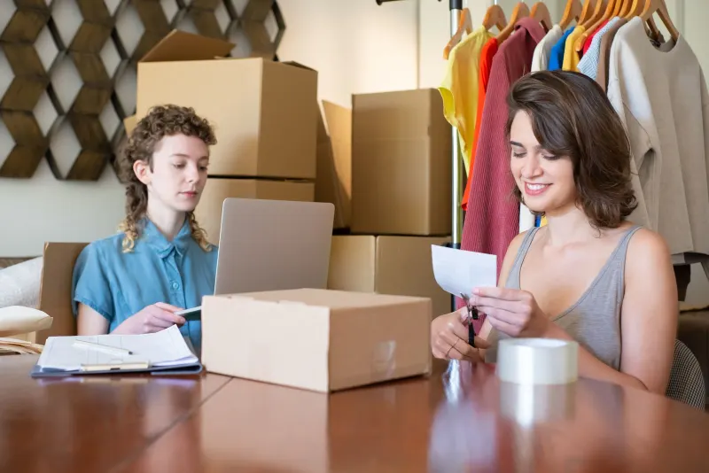 E-commerce workspace with laptop showing email dashboard and parcels ready to ship