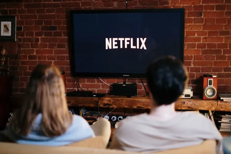 A couple watching Netflix on the couch in a cozy living room in December